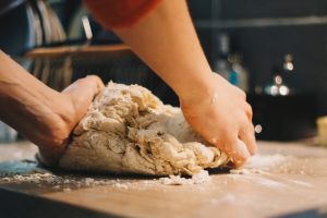 two hands kneading dough