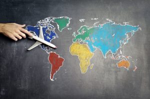 a person with a toy plane on a world map
