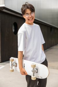 a single person smiling and holding a skateboard