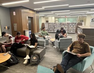 Harper FYS students sitting in the lounge area reading library materials